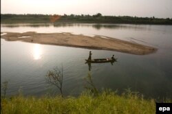 In this photo taken on Saturday, April 3, 2010, a Cambodian couple rows a wooden boat in Mekong river near Koh Touch village, Kandal province, about 22 kilometers (14 miles) north of Phnom Penh, Cambodia.