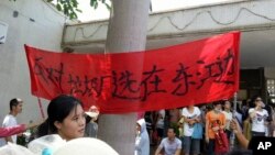 Protesters hold up a banner which reads "Against garbage incinerator along east river" in Boluo county in south China's Guangdong province, Sept. 14, 2014.