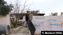 The word "Daeshy," meaning IS militant, is scrawled on a burnt-out house once belonging to a militant in a village outside of Mosul city in Iraq, Nov. 27, 2018.