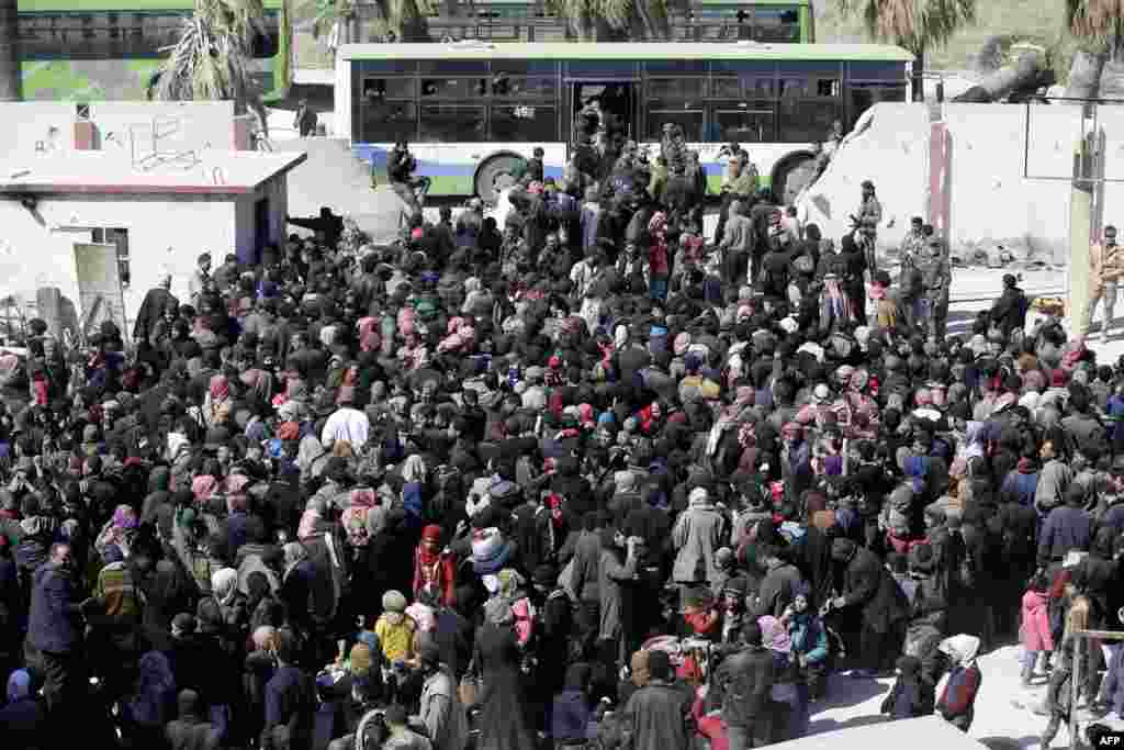 Syrian civilians, evacuated from rebel-held areas in the Eastern Ghouta, gather at a school in the regime-controlled Hosh Nasri, on the northeastern outskirts of the capital Damascus.