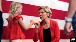 Democratic presidential candidate Sen. Elizabeth Warren, D-Mass., right, makes a pinky promise as she chats with Sydney Hansen, 8, of Oakland, Calif., during a campaign stop at town hall in Peterborough, N.H., Monday, July 8, 2019. 