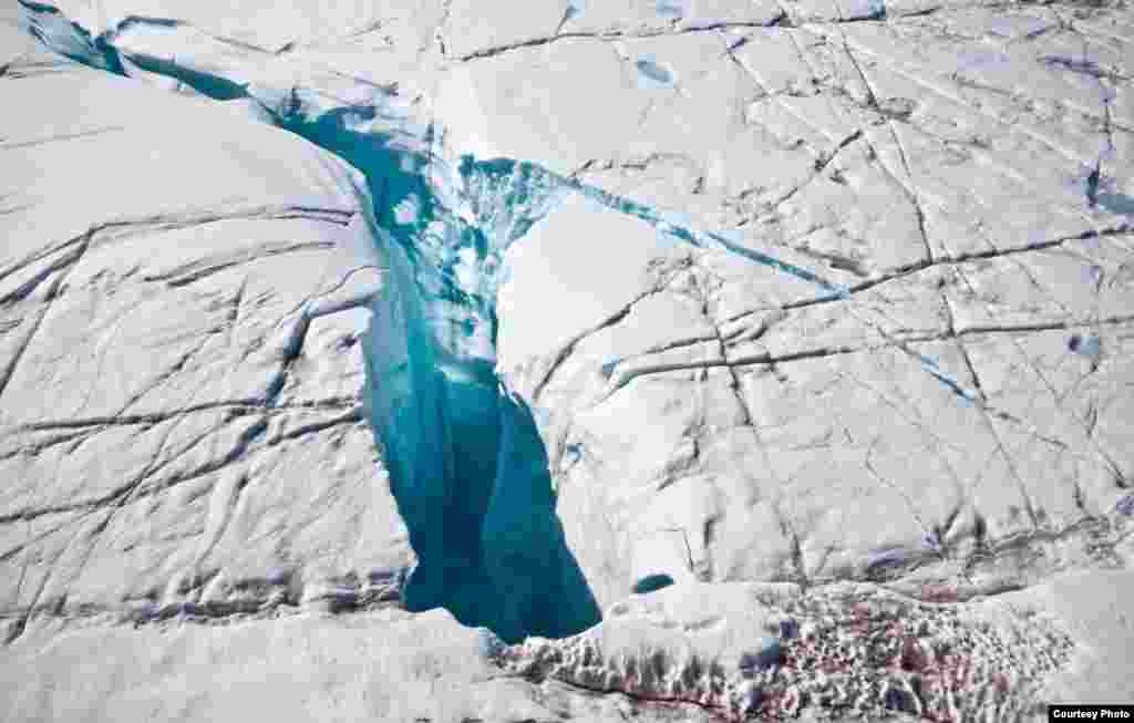 Moulin that drains surface meltwater through ice more than 3000 feet thick to reach base of the ice sheet, from where a subglacial drainage network ultimately routes it to the ocean. (Photo courtesy Ian Joughin)