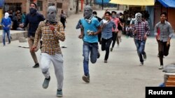 Protesters run as they prepare to hurl stones toward the Indian police during a protest after Friday prayers, in Srinagar, May 26, 2017. 