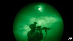 FILE - A U.S. soldier patrols at night in Khost province, Afghanistan, seen through night vision equipment. A U.S. official said Thursday that authorities are working to rescue an American citizen believed to have been kidnapped in the area.