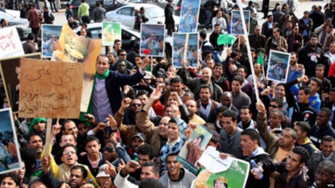 Pendukung pemerintah membawa poster pemimpin Muammar al-Gaddafi saat berkumpul menghadiri rapat umum pro-pemerintah di Tripoli, Rabu (2/16). Media pemerintah Libya tidak meliput protes-protes anti-Gaddafi yang berlangsung di berbagai tempat.