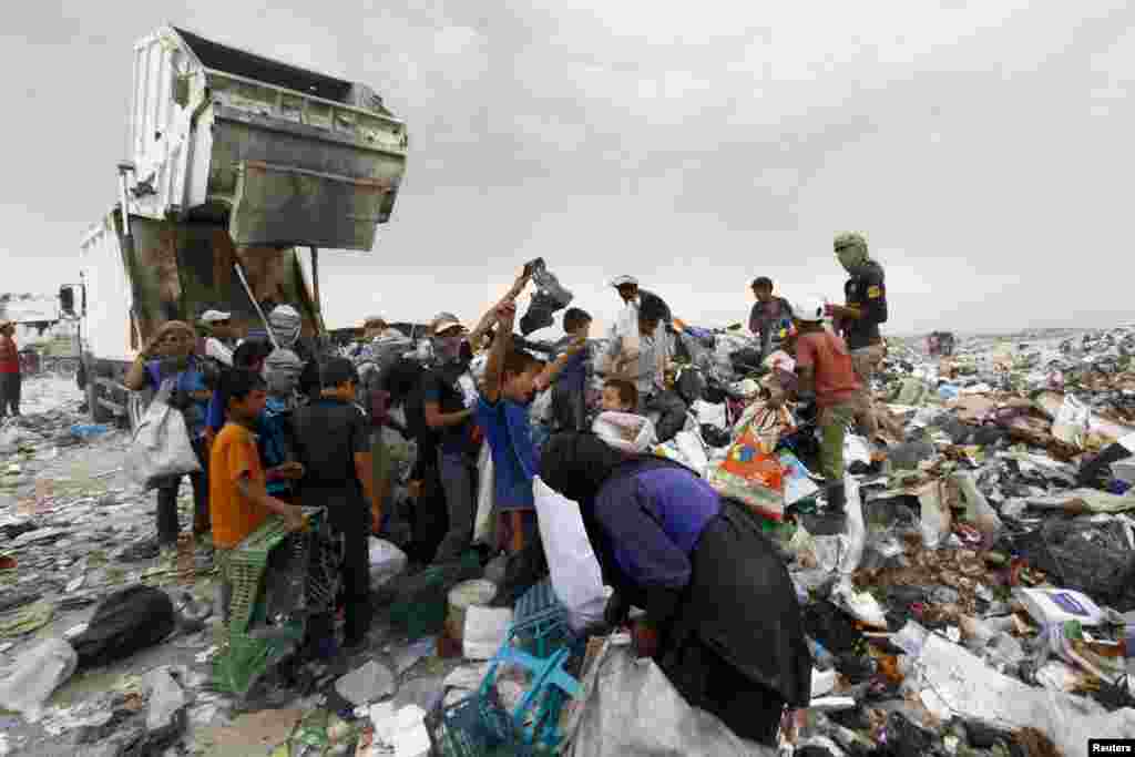 Warga memulung sampah yang masih bisa didaur ulang di kota Najaf, Irak.