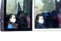 FILE - People ride on a public bus in Pyongyang, North Korea, Feb. 26, 2020. As a deadly virus closes in, North Korea presents itself as a fortress, tightening its borders while health officials stage a monumental disinfection and monitoring program.