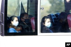 FILE - People ride on a public bus in Pyongyang, North Korea, Feb. 26, 2020. As a deadly virus closes in, North Korea presents itself as a fortress, tightening its borders while health officials stage a monumental disinfection and monitoring program.