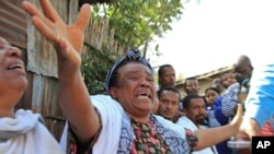 Des parents et amis non identifiés pleurent les Éthiopiens qui ont été détenus en Libye et tués par le groupe État islamique, dans le quartier pauvre du village de Cherkos à Addis-Abeba, en Éthiopie, lundi 20 avril 2015. (AP Photo)