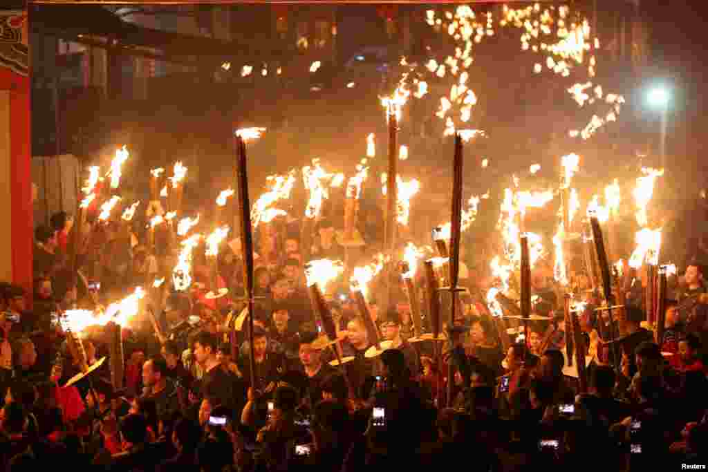 Villagers holding torches parade around a village during their Lunar New Year celebration to pray for good fortune, in Jinjiang, Fujian province, China.