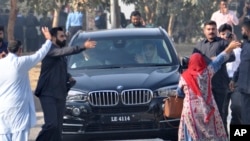 Maryam Nawaz, daughter of former Prime Minister Nawaz Sharif, right front passenger in vehicle, waves upon her arrival at an accountability court in Islamabad, Pakistan, Friday, Oct. 13, 2017. 