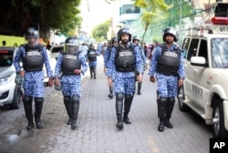 FILE - Maldivian policemen patrol the area where demonstrators gathered for a mass rally in Male', Maldives on Nov. 27, 2015.