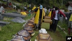 Wearing face masks to prevent infection, people carry a coffin containing the body of a landslide victim at a cemetery in Nova Friburgo, Brazil, 15 Jan 2011