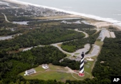 The Cape Hatteras lighthouse sits way off the beach in Buxton, NC., Saturday, Sept. 15, 2018. (AP Photo/Steve Helber)