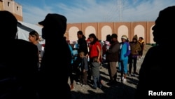 Migrants wait in line for food at a camp containing hundreds of migrants who arrived at the U.S. border from Central America in a caravan with the intention of applying for asylum in the U.S., in Tijuana, Mexico, Dec. 12, 2018. 