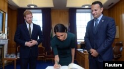 Pangeran Harry dari Inggris dan istrinya Meghan, yang sekarang bergelar Duke dan Duchess of Sussex, menandatangani buku tamu di kantor Taoiseach Leo Varadkar, pada awal kunjungan dua hari ke Dublin, Irlandia, 10 Juli 2018.