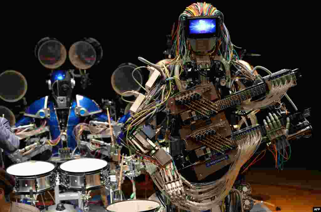 Robot guitarist "Mach" and robot drummer "Ashura" (L), members of a robot rock band "Z-Machines", perform music during the two day art and technology event "Maker Faire Tokyo" at the National Museum of Emerging Science and Innovation in Tokyo, Japan.