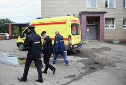 Un trabajador médico y agentes de policía caminan frente al Hospital de Emergencias Clínicas Número 1 de Oms la ciudad, donde ingresó el líder de la oposición rusa Alexei Navalny después de sufrir síntomas graves de envenenamiento según sus asesores.