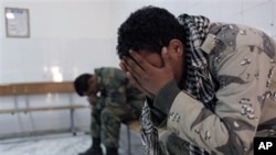 Two Libyan rebel fighters after their injured and killed colleagues were evacuated to the hospital of Ajdabiya, Apr 7 2011