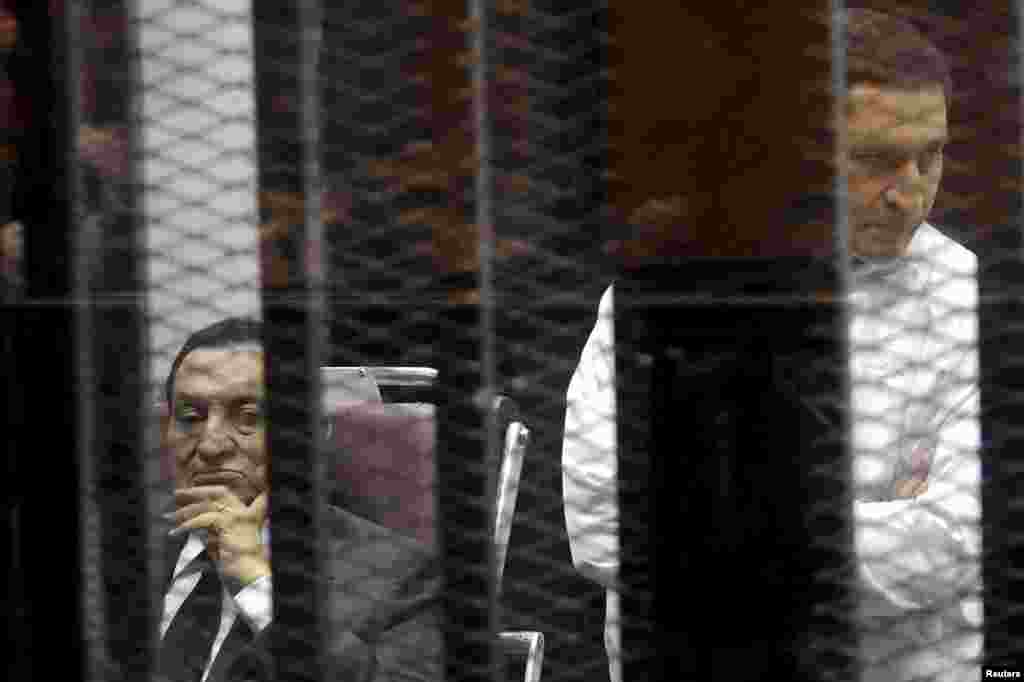 Presiden Mesir terguling Hosni Mubarak duduk di samping anaknya Alaa (kanan) di dalam sebuah ruangan di akademi polisi, di pinggiran kota Kairo, 21 Mei 2014.