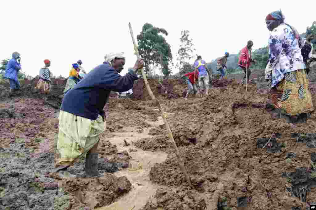 Rescue workers and people search for bodies after landslides following heavy rains buried 40 homes in the mountainous district of Bulambuli, eastern Uganda.