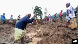 Warga dan petugas tanggap darurat tampak menggali lumpur untuk mencari korban tanah longsor di Bulambuli, di timur Uganda, pada 28 November 2024. (Foto: AP/Jean Watala)