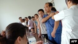 FILE - Residents queue up for their vaccine shots at a local hospital in Yuncheng, in northern China's Shanxi province.