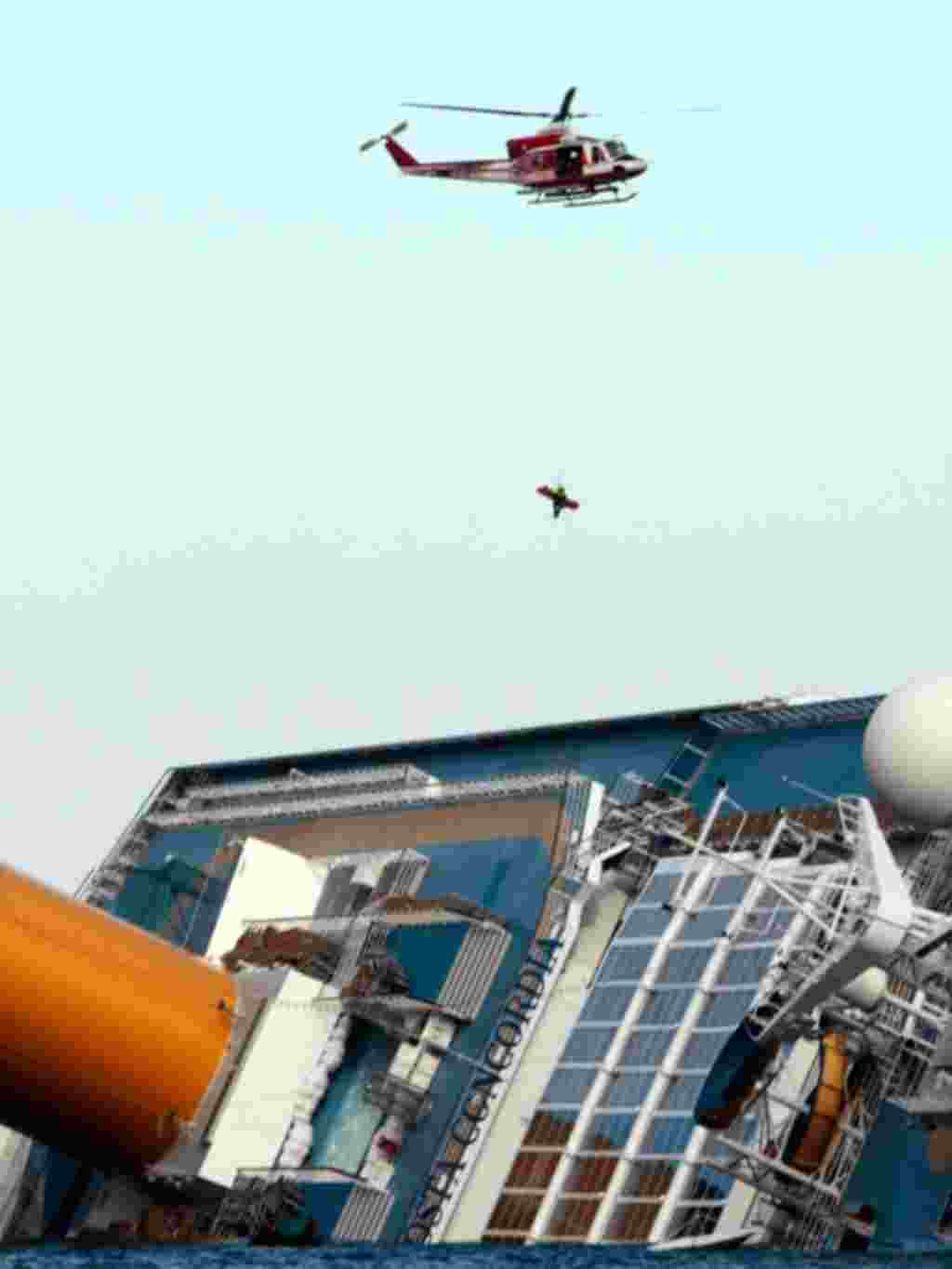 Helikopter pemadam kebakaran Italia menyelamatkan seorang penumpang dari kapal pesiar Costa Concordia, 15 Januari (AP).