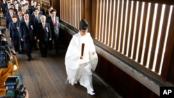 A group of Japanese lawmakers are led by a Shinto priest as they visit Yasukuni Shrine during the four-day annual Autumn Festival in Tokyo, Oct. 20, 2015.