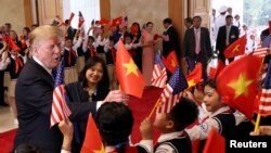 Presiden AS Donald Trump disambut para pelajar Vietnam menjelang pertemnuan dengan PM Nguyen Xuan Phuc (tidak nampak pada gambar) di Hall Kantor Pemerintah Vietnam di Hanoi, 27 February 2019. 