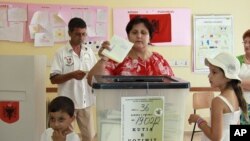 An Albanian voter casts her ballot in Tirana, Albania, June 23, 2013.