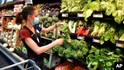 FILE - Crystal Dvorak shops at WinCo Foods, May, 7, 2021, in Billings, Mont. Dvorak was getting ingredients to make soup with potatoes and onions she got from a food bank after recently losing her job as an audiologist. 