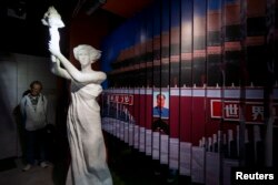 FILE - A visitor looks at a statue of the Goddess of Democracy at Hong Kong's museum dedicated to the Tiananmen Square pro-democracy protests, in Tsim Sha Tsui, April 26, 2014.