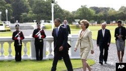 U.S. President Barack Obama and first lady Michelle Obama walk with Ireland's President Mary McAleese and husband Martin McAleese before a tree planting ceremony in Dublin, Ireland, May 23, 2011
