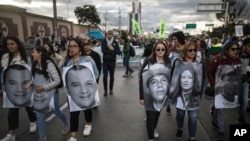 ARCHIVO - Manifestantes con fotos de activistas asesinados en Colombia protestan en Bogotá el 26 de julio de 2019.