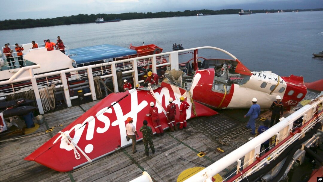 Awak kapal Crest Onyx bersiap mengeluarkan bagian pesawat AirAsia Flight 8501 dari kapal di pelabuhan Kumai di Pangkalan Bun (11/1). (AP/Achmad Ibrahim)