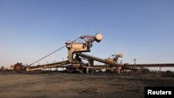 FILE - A universal machine stands in open ground near the conveyor belt at coal handling plant at the Pakistan Steel Mills on the outskirts of Karachi, Pakistan, Feb. 8, 2016. 