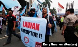 Para pengunjuk rasa meneriakkan slogan-slogan saat aksi mendukung Komisi Pemberantasan Korupsi (KPK) di luar kantor KPK di Jakarta 8 Oktober 2012. Mereka mambawa spanduk bertuliskan, "Lawan koruptor". (Foto: REUTERS/Enny Nuraheni)