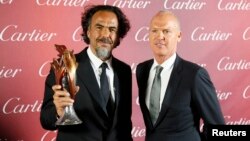 'Birdman' Director Alejandro Gonzalez Inarritu, left, holds his Director of the Year Award as he poses with actor Michael Keaton at the 26th Annual Palm Springs film festival in Palm Springs, Calif., Jan. 3, 2015.
