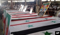 Photo released by the Syrian official news agency SANA shows mourners at a mass funeral of people killed a day earlier by a series of suicide bombings launched by the Islamic State's fighters on the eastern and northern countryside of the southern province of al-Sweida during a in al-Sweida, Syria, July 26, 2018.