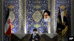 آیت الله خامنه ای، رهبر جمهوری اسلامی، در کنار پرچم منقوش به آرم سپاه پاسدارن و در حال سخنرانی برای اعضای بسیج - آرشیو