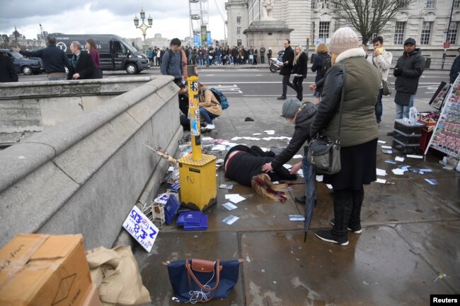 A woman lies injured after a shottingt incident on Westminster Bridge in London, March 22, 2017.