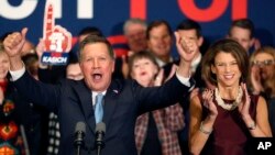 With his wife Karen at his side Republican presidential candidate Ohio Gov. John Kasich cheers with supporters, Feb. 9, 2016, in Concord, N.H., at his primary night rally.