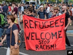 Protesters demonstrate with a banner 'Refugees welcome!' in Dresden, eastern Germany, Aug. 29, 2015. A refugee shelter was attacked by far-right protesters in Heidenau near Dresden over the last weekend.