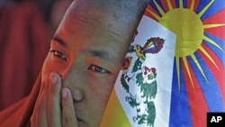 A Tibetan monk holds a flag as he takes part in a day-long hunger strike in New Delhi, October 19, 2011.
