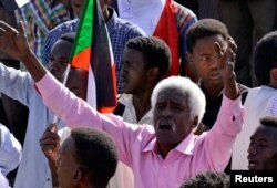 A Sudanese demonstrator celebrates after Defense Minister Awad Ibn Auf stepped down as head of the country's transitional ruling military council, near the Defense Ministry in Khartoum, Sudan, April 13, 2019.