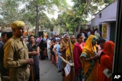 Indians stand in queues to cast their votes at a polling booth for the first phase of general elections, near Ghaziabad, India, April 11, 2019.