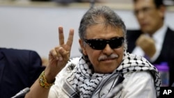 FILE - Former FARC rebel Seuxis Hernandez, also known as Jesus Santrich, flashes a victory sign at journalists as he attends a session of the Chamber of Representatives at the Colombian congress in Bogota, Colombia, June 12, 2019.