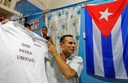 FILE - Jose Daniel Ferrer, who leads the Patriotic Union of Cuba, the country's largest dissident group, holds a T-shirt with the writing "God, Fatherland, Freedom" in Palmarito de Cauto, Cuba, March 25, 2012.