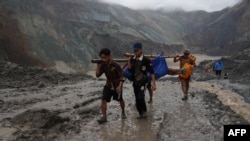 Tim penyelamat menemukan mayat di dekat daerah longsor di lokasi penambangan batu giok di Hpakant di negara bagian Kachin pada 2 Juli 2020. (Foto: AFP)